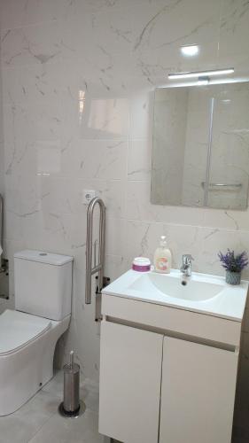 a white bathroom with a sink and a toilet at Casas do Maranhão Póvoa de Varzim in Navais