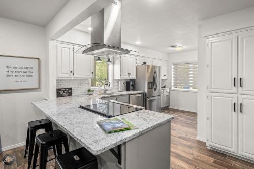 een keuken met witte kasten en een aanrechtblad bij Modern 2BR Townhouse - Near Bike Trails & Golf in Dug Hill