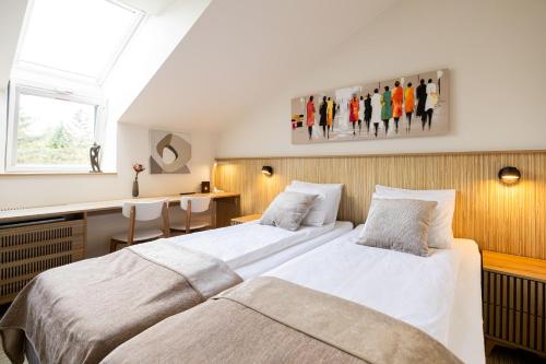 Un dormitorio con dos camas y un escritorio. en Embassy Studio 303, en Vilna