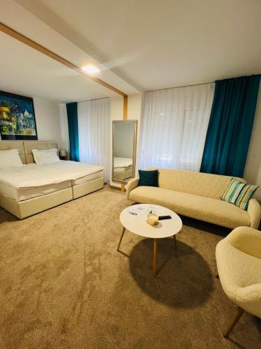 a living room with a bed and a couch and a table at Hotel Panonija in Sisak