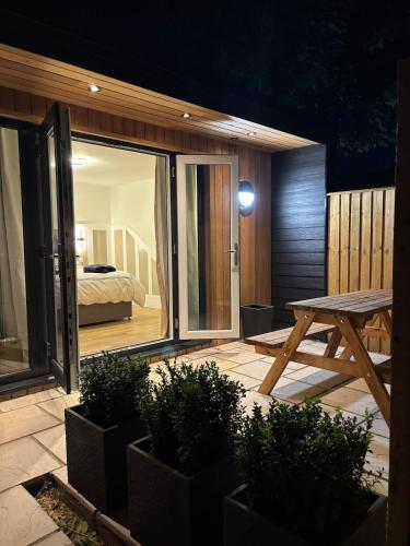 a patio with a table and a bed in a bedroom at Stylish Garden pod lodges in Milton
