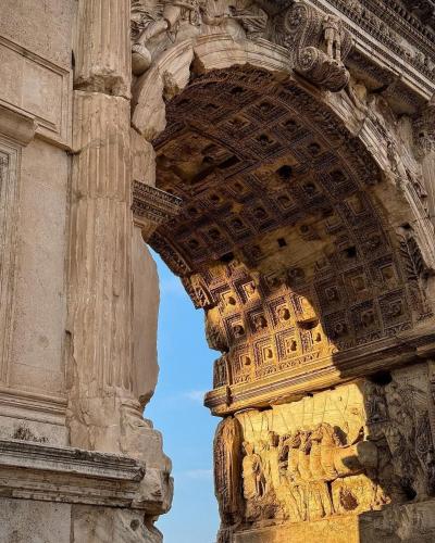 an arch in a stone building with a blue sky at Domus Colosseum, detached house just few steps from the Colosseum in Rome