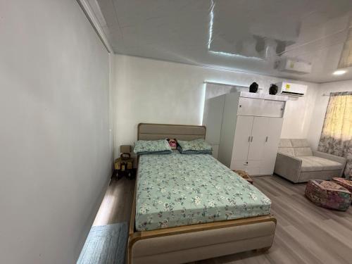 a small bedroom with a bed and a couch at Casa taj beach house in La Loma