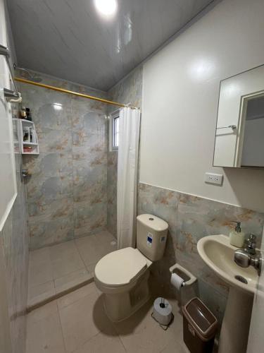 a bathroom with a toilet and a shower and a sink at Casa taj beach house in La Loma