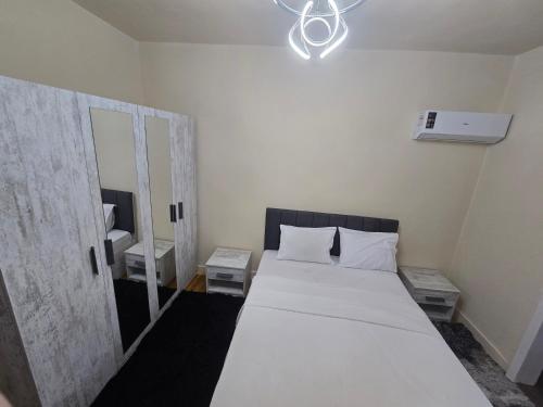 a bedroom with a white bed and a mirror at Alex Gate apartment - families only in Alexandria