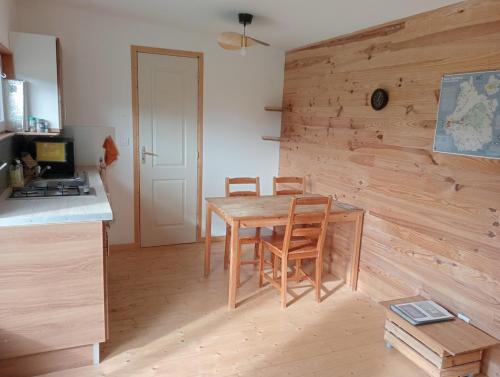 - une cuisine avec une table et des chaises en bois dans la chambre dans l'établissement La tiny house au cœur de la nature, à Saint-Roch