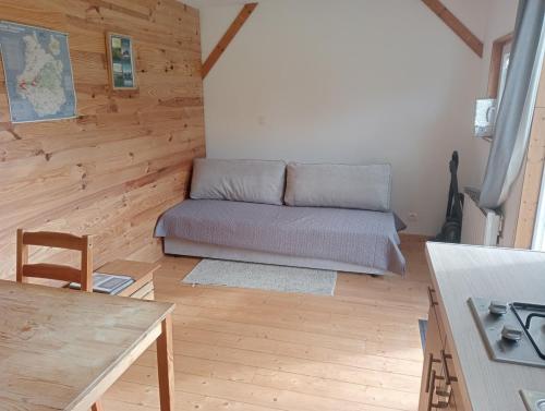 un salon avec un canapé et une table dans l'établissement La tiny house au cœur de la nature, à Saint-Roch