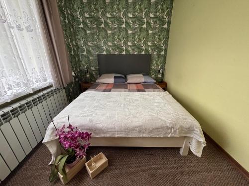a small bedroom with a bed with flowers on the floor at U Małgorzaty in Wojtkowa