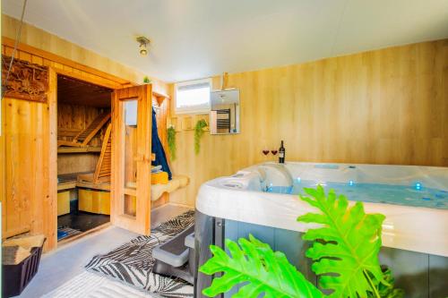 a bathroom with a large tub in a room at Wellness oase Egmond in Egmond aan den Hoef