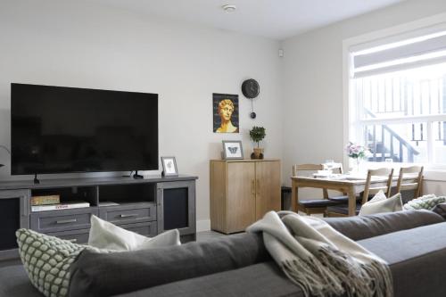 a living room with a couch and a flat screen tv at Cozy 2BR for Family & Private Parking & Near Mall in Langley