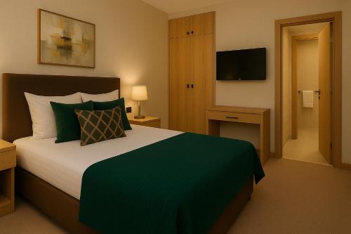 a bedroom with a large bed with a green blanket at Xetai Royal Hotel in Baku