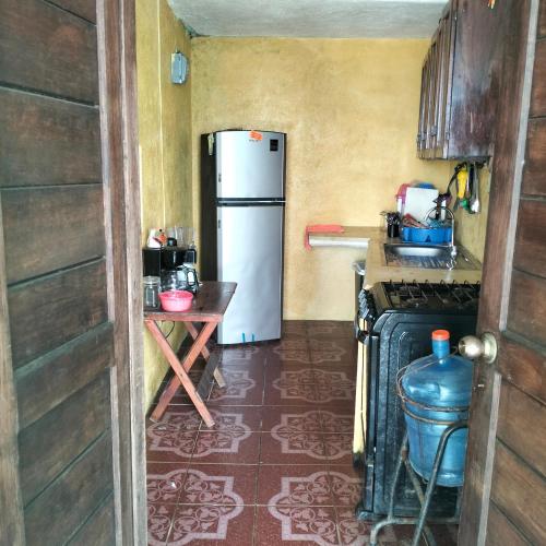 a kitchen with a refrigerator and a table in it at ecohabitas in Mazunte
