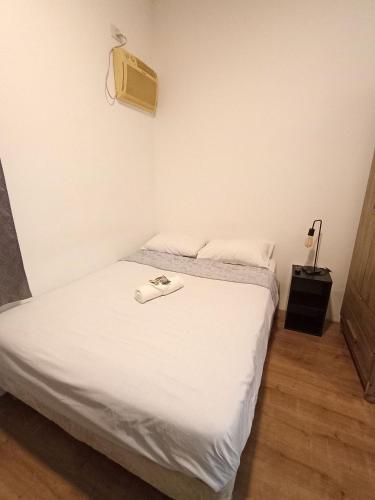 a small room with a bed with white sheets at WeStay Nova Cidade in São Paulo