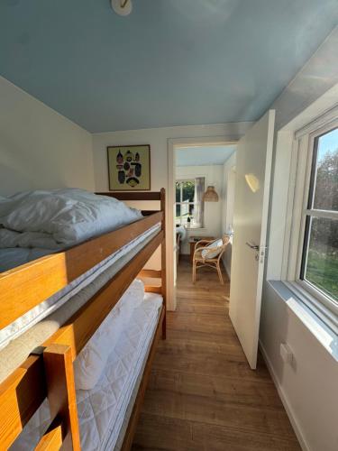 a bedroom with a bunk bed and a window at Smukt sommerhus nær Ribe C inkl rengøring in Ribe