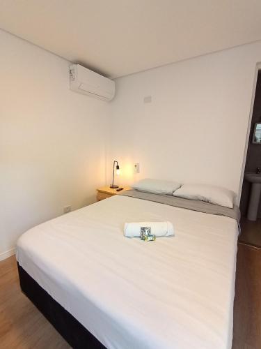 a bedroom with a white bed with a towel on it at WeStay Nova Cidade in São Paulo