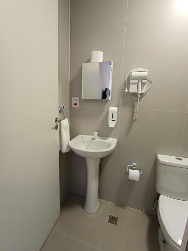 a bathroom with a sink and a toilet and a mirror at WeStay Nova Cidade in São Paulo