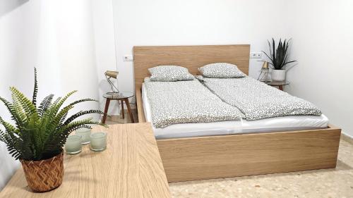 a bedroom with a bed and a table with a plant at Paraíso Soleado Estepona Costa Del Sol in Estepona