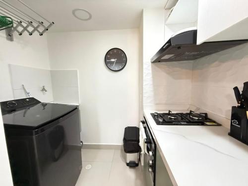 a kitchen with a stove and a clock on the wall at Beautiful Apartment in Cartagena in Estación El Salto