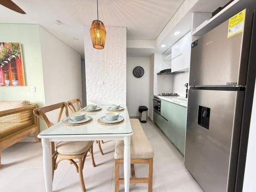 a kitchen with a white table and a refrigerator at Beautiful Apartment in Cartagena in Estación El Salto