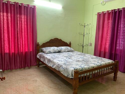 a bed in a room with red curtains and a bed sidx sidx sidx at Serenity Retreat in Varkala