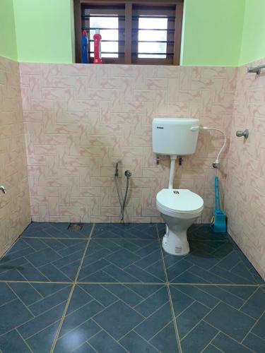 a bathroom with a toilet in a room at Serene Retreat in Varkala
