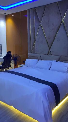 Un dormitorio con una gran cama blanca y una silla. en M-Square Home, en Iranla
