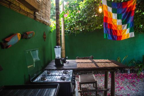 a kitchen with a table and a colorful wall at Caju com Mel Hospedagem in Moreré