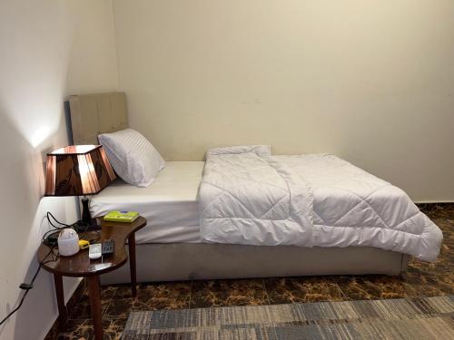 a bedroom with a bed and a table with a lamp at El Khalil Pyramids View Inn in Cairo