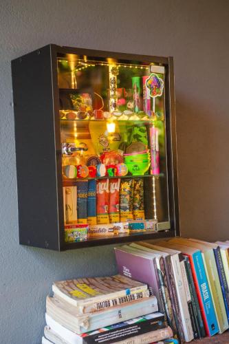a refrigerator full of food and drinks on top of books at Caju com Mel Hospedagem in Moreré