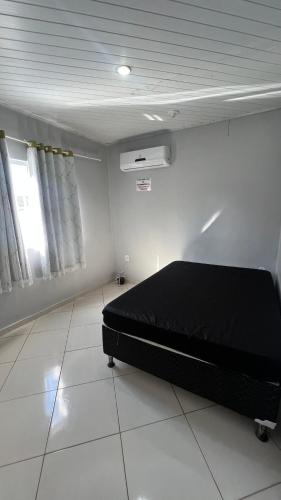 a bedroom with a black bed in a room at Casa temporada Guarapari in Guarapari