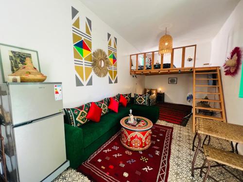 a living room with a green couch and a refrigerator at Art riad au bord de la mer 1 in El Jadida