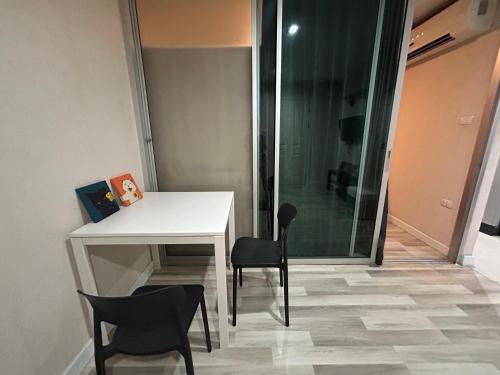 a desk and chairs in a room with a shower at Secret Pastel Room Laksi Donmuang Airport ห้องลับพาสเทลหลักสี่สนามบินดอนเมือง in Lak Si