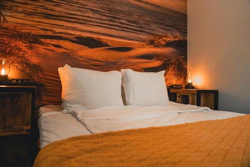 una camera da letto con un letto con lenzuola e cuscini bianchi di Het Willemshuis a Willemstad