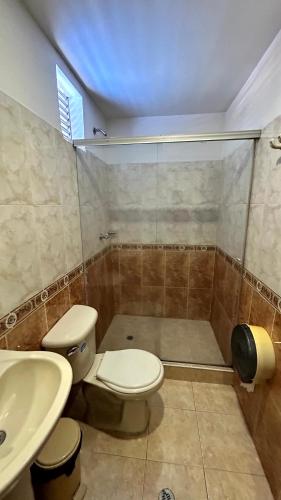 a bathroom with a toilet and a shower and a sink at Hotel Imperio in Ibagué