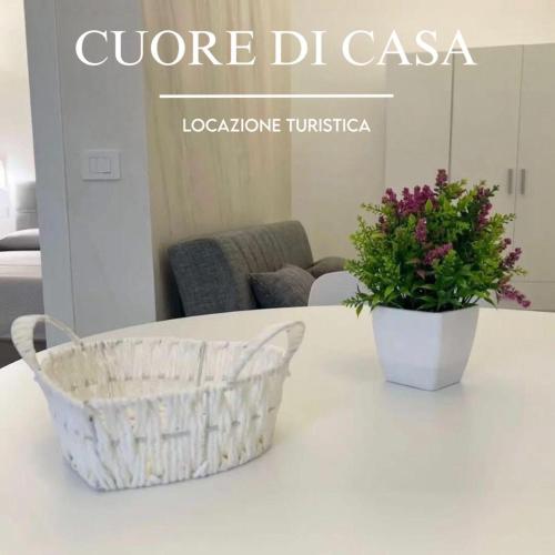 a white table with a basket and flowers on it at Cuore di casa in Manfredonia