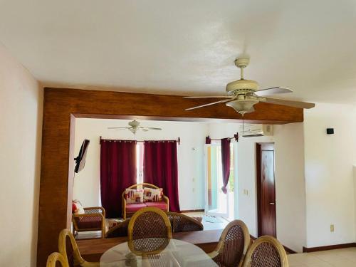 a living room with a ceiling fan and a table at VILLAS RIBERA DEL PACIFICO in Ixtapa