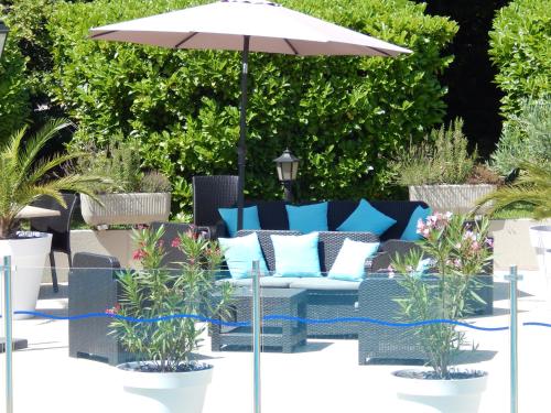 a patio with a blue couch and an umbrella at Mercure Orange Centre A7/A9 in Orange