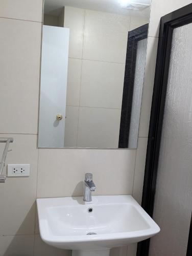 a bathroom with a white sink and a mirror at The Cozy Hub in Baguio