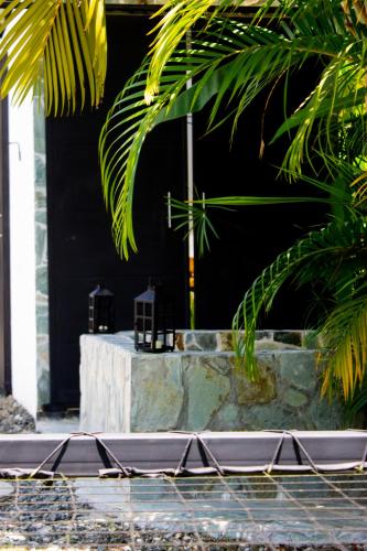 a building with a black wall and some trees and a table at Orange Eco Villas in Quimbaya