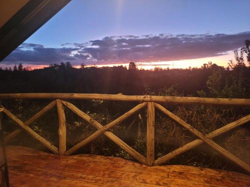 a sunset seen through a wooden fence at DesertDewEstate in Nanyuki