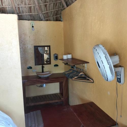a bathroom with a sink and a fan on the wall at ecohabitas in Mazunte