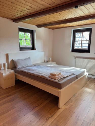 a large bed in a room with two windows at Nr7 Das Ferienhaus in Hameln