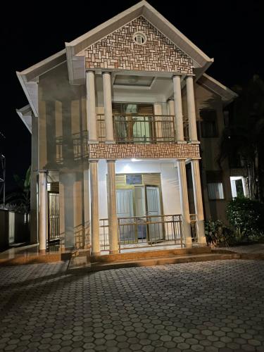 a white house with a balcony on a street at KIGALI LIGHT HOMEs in Kigali