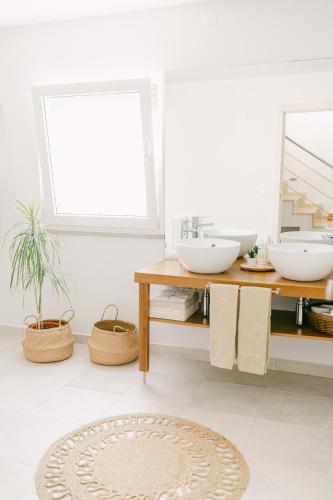 a bathroom with two sinks and two mirrors at Casa dos Rosas in Gavião