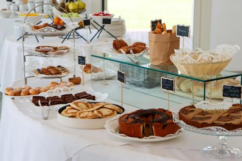a table with different types of pastries and desserts at Seven Park Hotel Lake Como - Adults Only in Colico