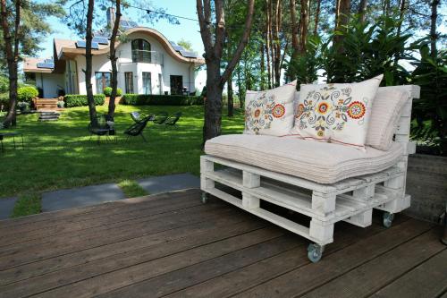 a white chair on a wooden deck in front of a house at Modra Sikorka in Smardzewice