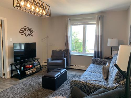 a living room with a couch and a tv at Mariners Nest in Saint John
