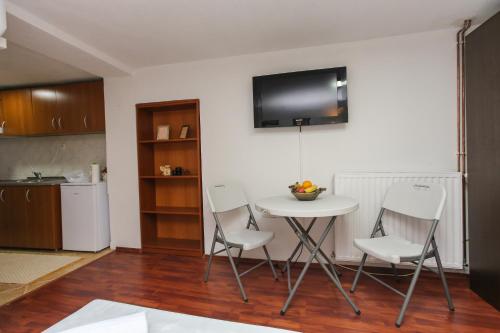 eine Küche mit einem Tisch, 2 Stühlen und einem TV in der Unterkunft Apartment Pajevic in Mostar