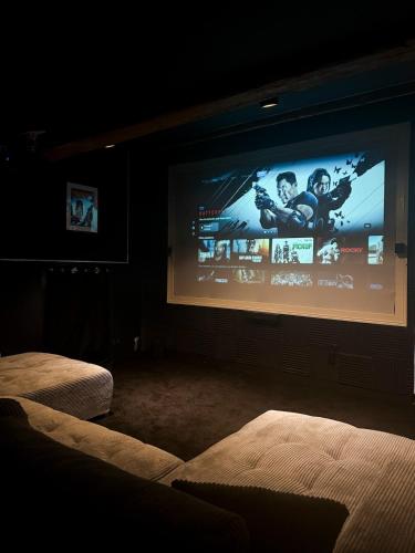 Una pantalla grande en una habitación oscura con una película en ella. en Cinema Loft, en Elne