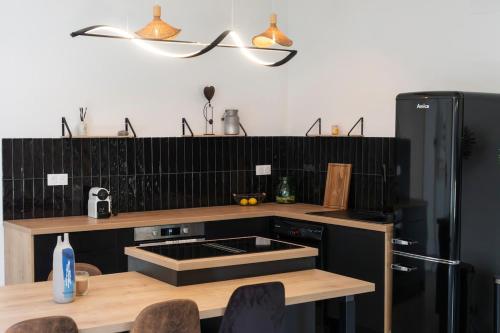 Una cocina con refrigerador y una mesa con sillas. en Cinema Loft, en Elne